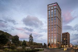 a tall glass building with a sky at Moxy Dublin Docklands in Dublin