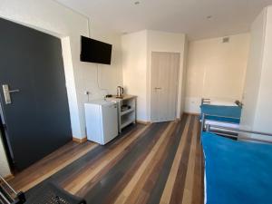 a small room with a refrigerator and a bed at Noclegi in Starachowice