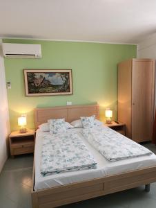 a bedroom with a bed and two lamps on tables at Apartments & Rooms Karmen in Portorož