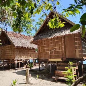 a wooden house with a thatched roof at Batanta Explorers in Pulau Saonek-kecil