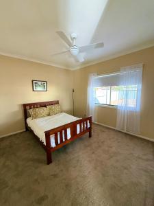 a bedroom with a bed and a ceiling fan at Ferguson House in Cessnock