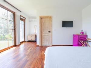 a bedroom with a bed and a tv on a wall at Muyo House in Urla