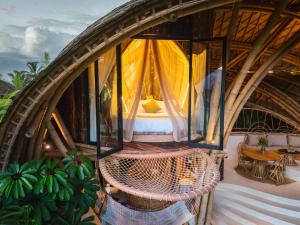 a bedroom in a dome shaped room with a bed at Green Earth Bali luxury Bamboo villas in Sidemen