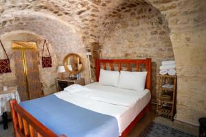 a bedroom with a bed in a stone wall at sermest house in Urfa