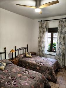 a bedroom with two beds and a ceiling fan at El Herrador in Nájera