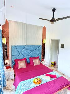 a bedroom with a large pink bed with a blue headboard at Eko Nest Grand 5BHK Villa in Lonavala