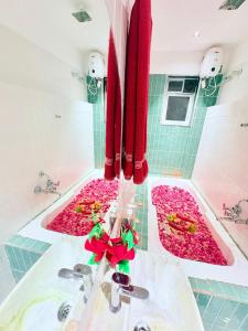 a bathroom with a tub filled with pink flowers at Eko Nest Grand 5BHK Villa in Lonavala