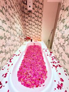 a bath tub filled with lots of pink flower petals at Eko Nest Grand 5BHK Villa in Lonavala +31 photos