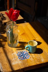 a vase with a rose and a cup of coffee on a table at Borgata Giostra in Caprie