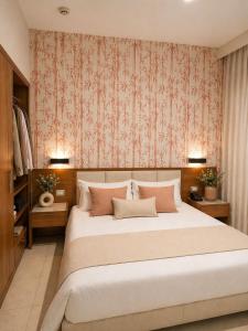 a bedroom with a large bed with pink wallpaper at Hotel La Costiera in Varcaturo +30 photos