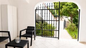 a room with an open gate with chairs and a table at Casa Marisella in San Teodoro +27 photos