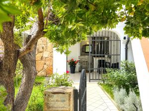 an entrance to a house with a gate and a tree at Casa Marisella in San Teodoro
