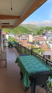 a table on a balcony with a view of a city at Ensol B&B in Peshkopi