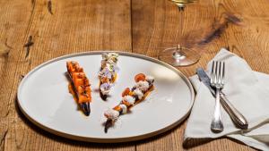 a white plate with food on a wooden table at Hueber der Wirt in Sankt Georgen an der Leys