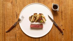 a white plate with food on a wooden table at Hueber der Wirt in Sankt Georgen an der Leys +2 photos