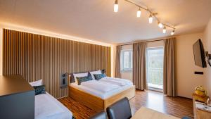 a hotel room with a bed and a large window at Hueber der Wirt in Sankt Georgen an der Leys