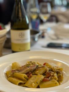 a plate of pasta with a bottle of wine at Albergo Centrale in San Ginesio