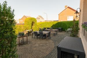 a patio with tables and chairs on a brick patio at B&B Castellier in Lier