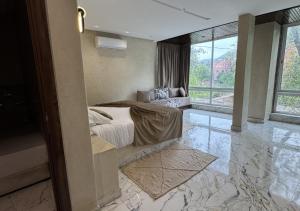 una camera da letto con un letto e una grande finestra di Hotel Asael a Ourika
