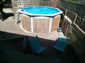 two chairs and a hot tub with two chairs around it at la mini ferme de maëlou in Sermaises