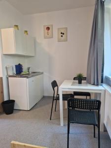 a kitchen with a table and chairs and a white table at Gruppenunterkunft für Firmen & Arbeiter in Laa an der Thaya in Laa an der Thaya
