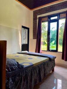 a bed in a room with a large window at Toraja Bungin Family House in Rantepao