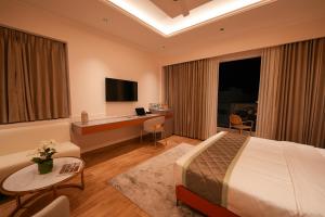 a hotel room with a bed and a desk at Hotel California in Bangalore