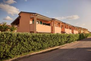 a building with bushes in front of a street at Badesi Sea Dunes in Codaruina