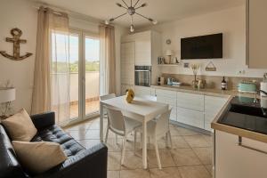 a kitchen and living room with a table and a couch at Badesi Sea Dunes in Codaruina