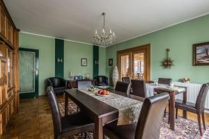 ein Esszimmer mit grünen Wänden sowie einem Tisch und Stühlen in der Unterkunft Hotel-Pension am Rosarium in Sangerhausen