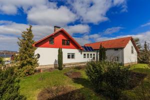 ein weißes Haus mit rotem Dach auf einem Hügel in der Unterkunft Hotel-Pension am Rosarium in Sangerhausen