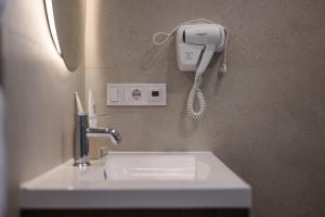 a bathroom with a sink and a phone on the wall at ММ GROUP APARTMENT in Uzhhorod +244 photos