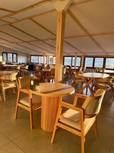 a restaurant with wooden tables and chairs and windows at The Yücedağ Hotel in Arapkir