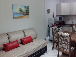 a living room with a couch and a kitchen at Sol da Cachoeira in Florianópolis