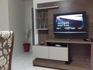 a flat screen tv sitting on top of a entertainment center at Sol da Cachoeira in Florianópolis