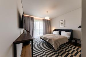 a bedroom with a bed and a desk and a window at ММ GROUP APARTMENT in Uzhhorod