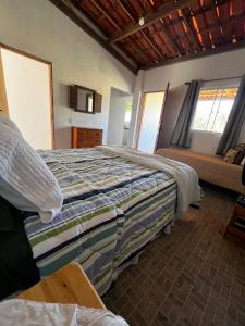 a bedroom with a large bed and a couch at Chales Estiva Nova in Mucugê