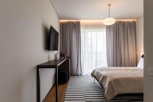 a hotel room with a bed and a window at ММ GROUP APARTMENT in Uzhhorod
