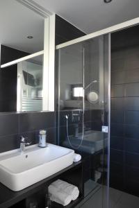 La salle de bains est pourvue d'un lavabo et d'une douche en verre. dans l'établissement Porta Vinea, à Ruppertsberg
