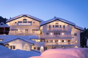 a large white building in the snow at night at Le Chabichou Hotel & Spa in Courchevel