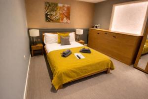 a bedroom with a bed with a yellow blanket at The Tower Arms Hotel in Iver