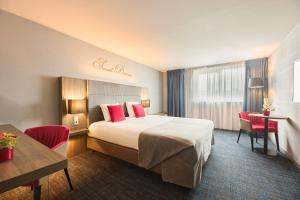 a hotel room with a large bed with red pillows at Van der Valk Hotel Liège Congres in Liège