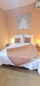 a bedroom with a large bed with white sheets and pillows at Ti Ker Créole in Saint-Benoît