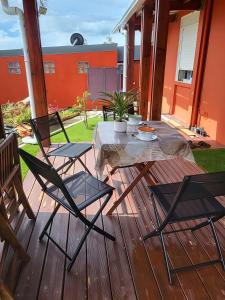 a wooden deck with a table and chairs on it at Ti Ker Créole in Saint-Benoît