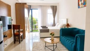 a living room with a blue couch and a bed at Casa Liora Studio by UN & Two Rivers in Nairobi