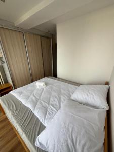 a bed with white sheets and pillows in a room at PINKY SQUARE apartman in Zvolen +2 photos