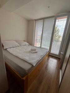 a large bed in a room with windows at PINKY SQUARE apartman in Zvolen