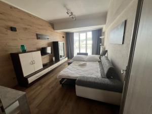 a bedroom with a bed and a couch at PINKY SQUARE apartman in Zvolen