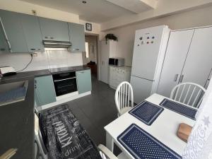 a kitchen with a table with chairs and a refrigerator at PINKY SQUARE apartman in Zvolen