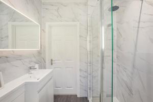 a white bathroom with a shower and a sink at 2 Bed in Snape oc-12sf in Snape +15 photos